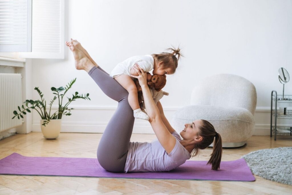 young woman exercising with her small child